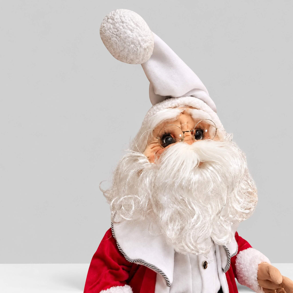 Handmade Santa Claus standing next to his removable head, torso, and legs on a display table.