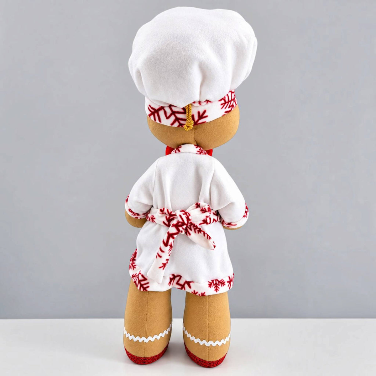 Back view of handmade Christmas Gingerbread Baker showing removable clothing, chef hat, tied waist sash, and detailed holiday outfit.