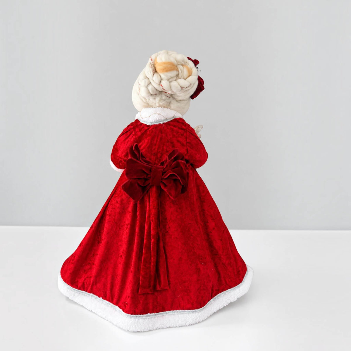 Back view of Mrs. Claus showing the large bow and white trim on her red Christmas dress.