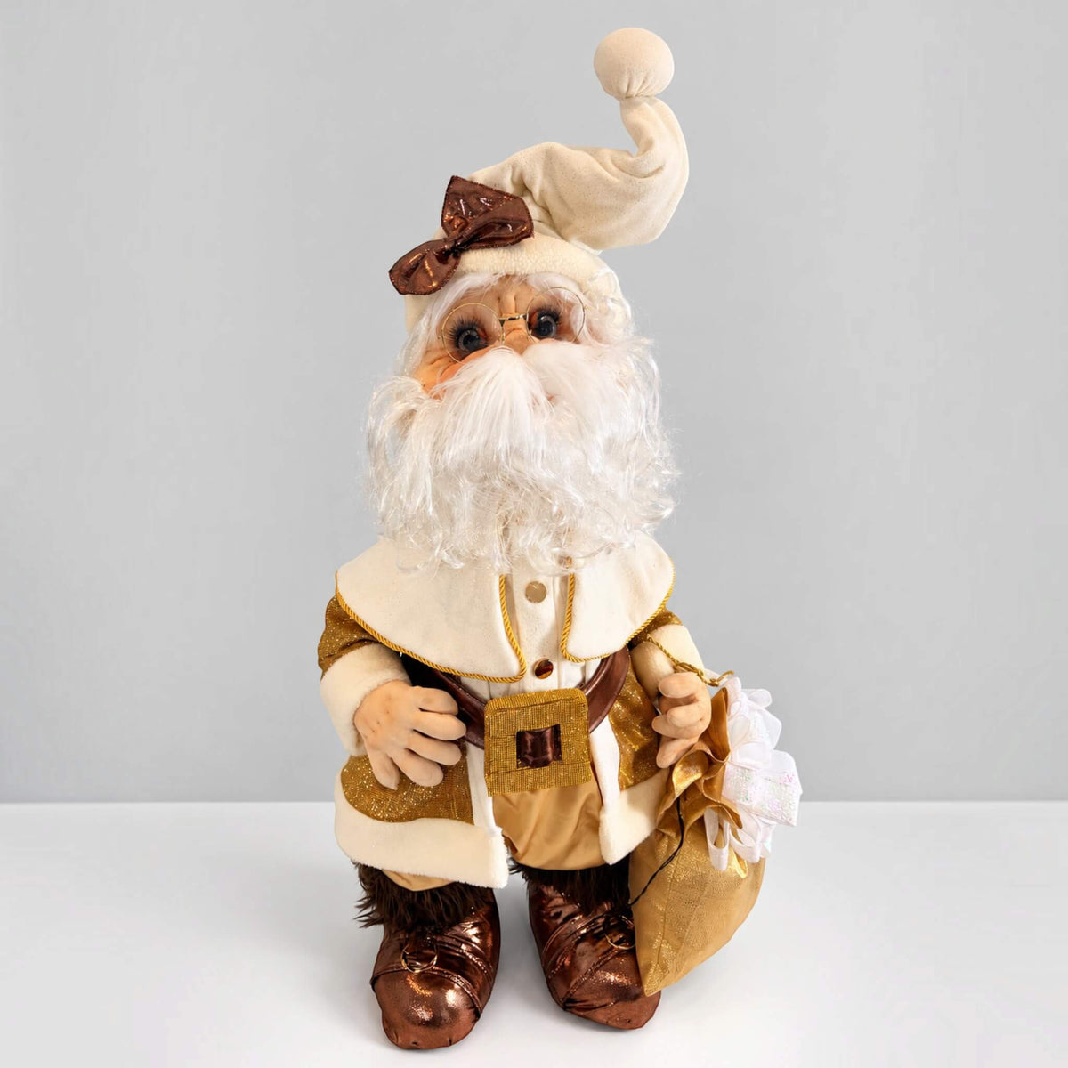 Full view of handmade Santa Claus in a gold and cream outfit, holding a gold gift bag.