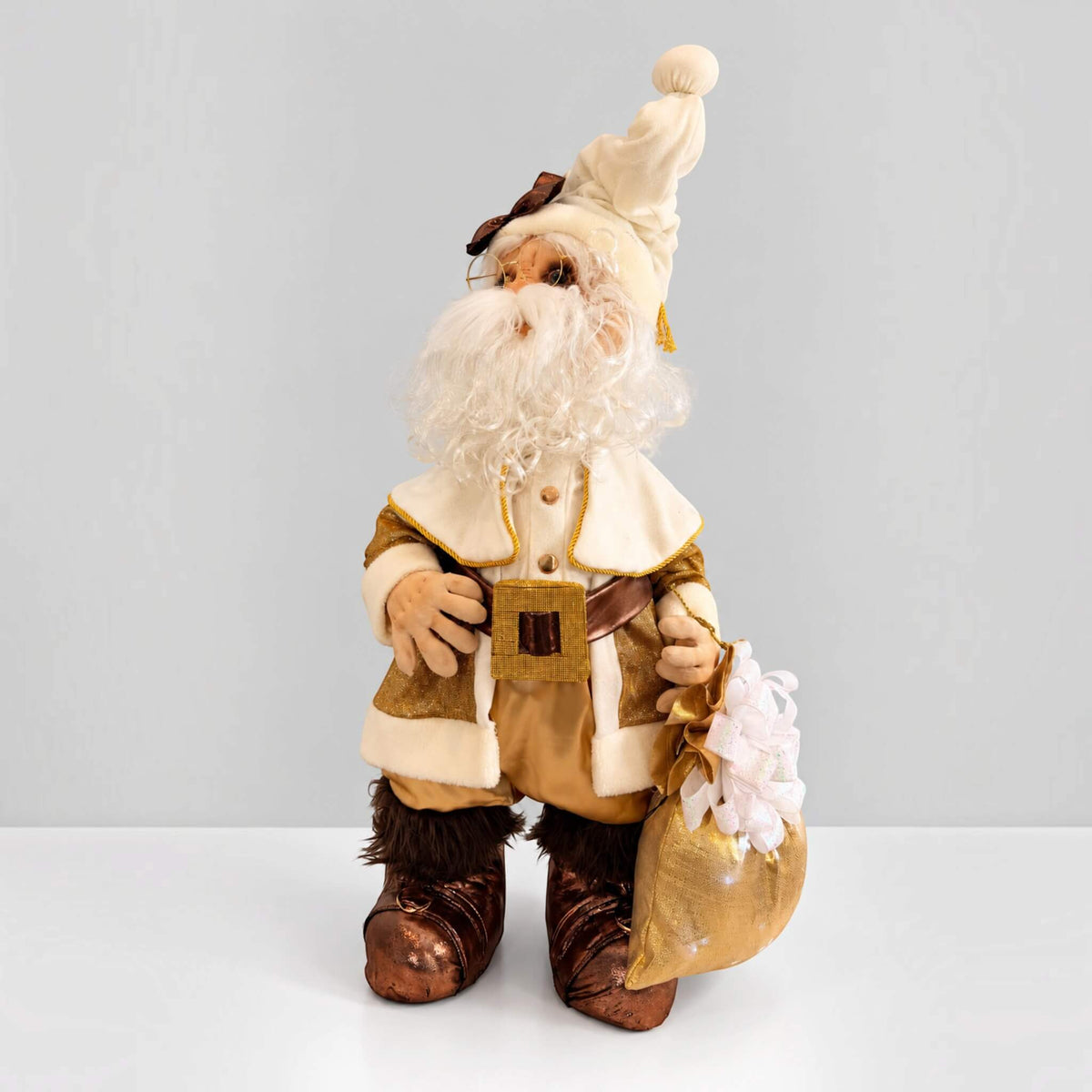 Three-quarter view of handmade gold Santa Claus with a white beard and gold gift bag.