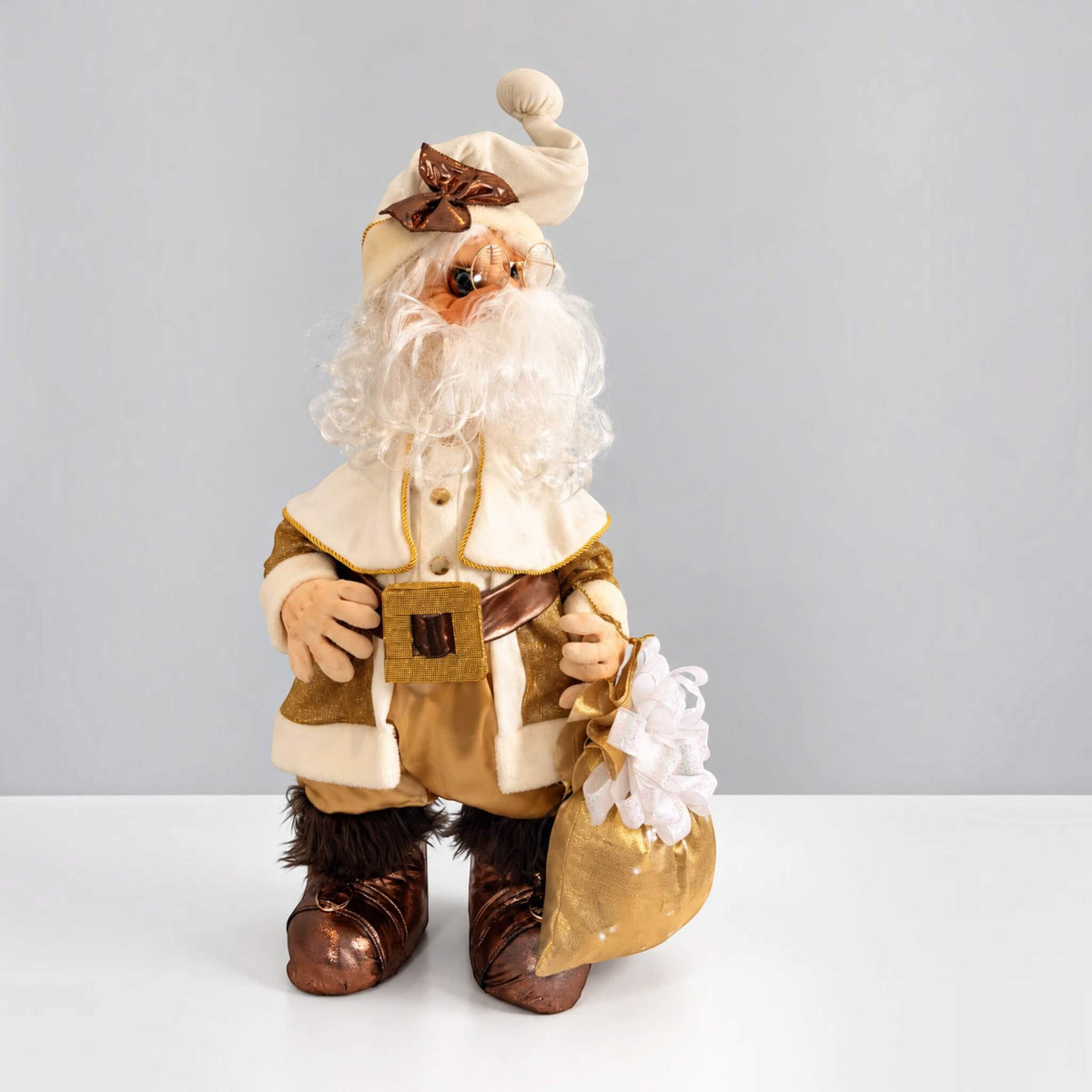 Front view of handmade Santa Claus wearing a gold and cream Christmas outfit and carrying a gift bag.