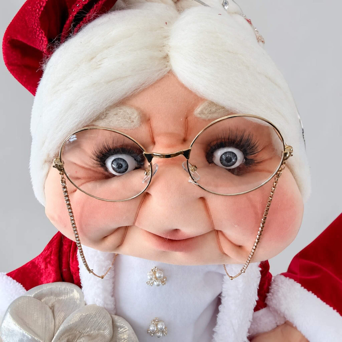 Full-length three-quarter view of Mrs. Claus wearing a red Christmas dress with white trim.